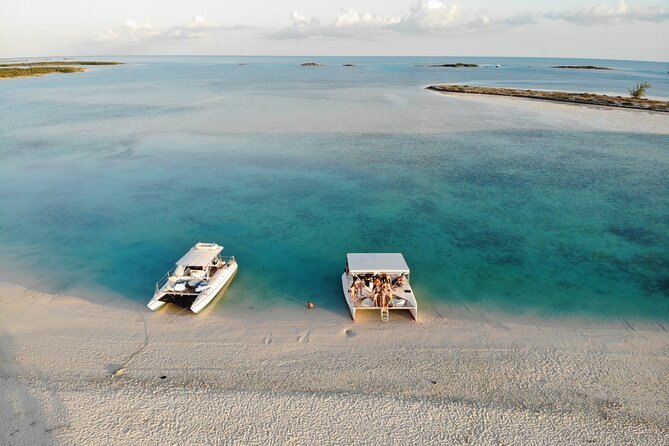 Two catamarans beached side by side at a sandbar, seen from the air