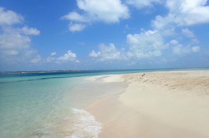 A white-sand beach running into pale turquoise shallows